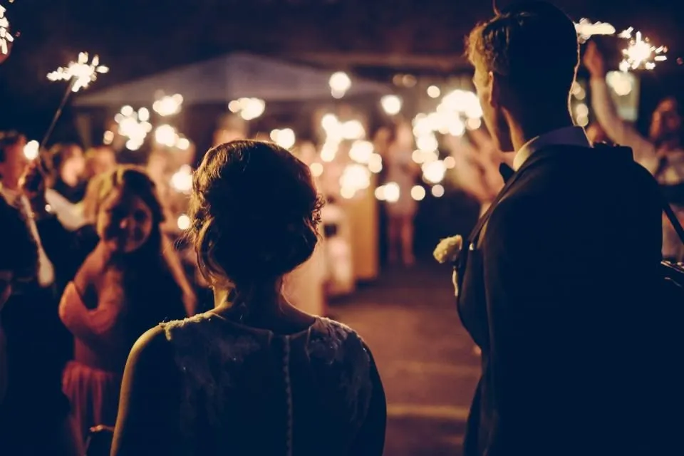 Invitados con luces de bengala encendidas durante una fiesta de noche