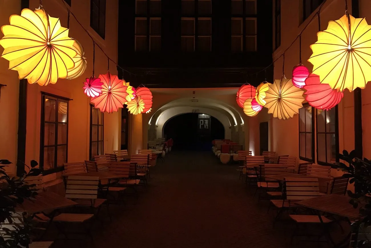 Patio interior iluminado con lámparas de papel de colores al anochecer